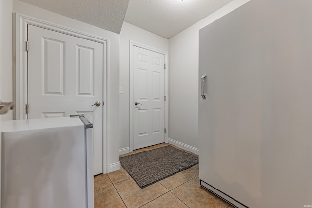 7680 Saint Jordan Cir, Newburgh, IN 47630 - laundry area with light tile patterned floors, baseboards, and a textured ceiling