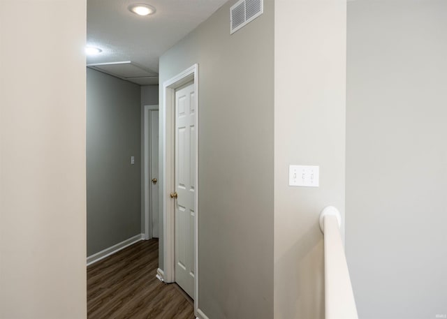 hall with dark wood-style flooring and baseboards