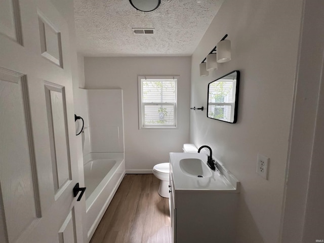 2108 W Memorial Dr, Muncie, IN 47302 - bathroom featuring wood finished floors, toilet, vanity, baseboards, and a textured ceiling