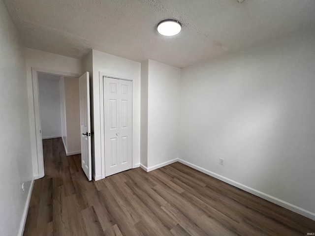 2108 W Memorial Dr, Muncie, IN 47302 - unfurnished bedroom featuring wood finished floors, baseboards, a closet, and a textured ceiling
