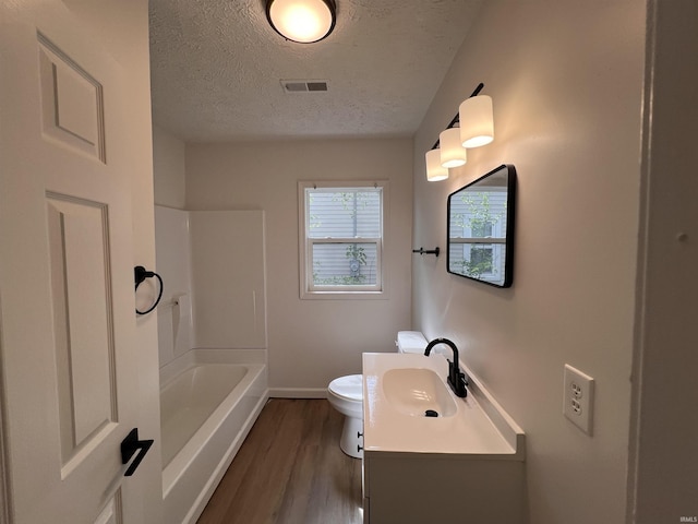 2108 W Memorial Dr, Muncie, IN 47302 - bathroom featuring a textured ceiling, wood finished floors, vanity, baseboards, and toilet