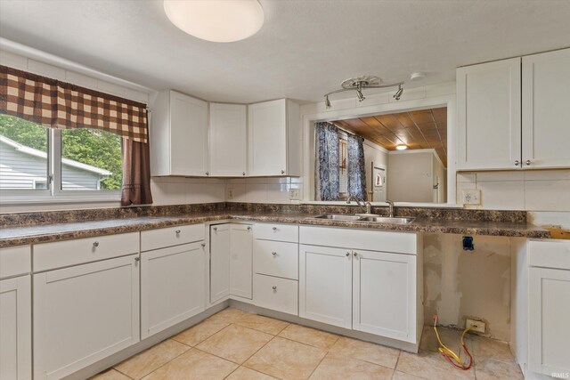 114 S Grand St, Lakeville, IN 46536 - kitchen featuring a sink, white cabinets, light tile patterned floors, and dark countertops