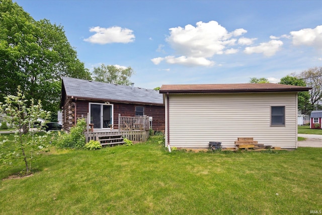 rear view of house featuring a deck and a lawn