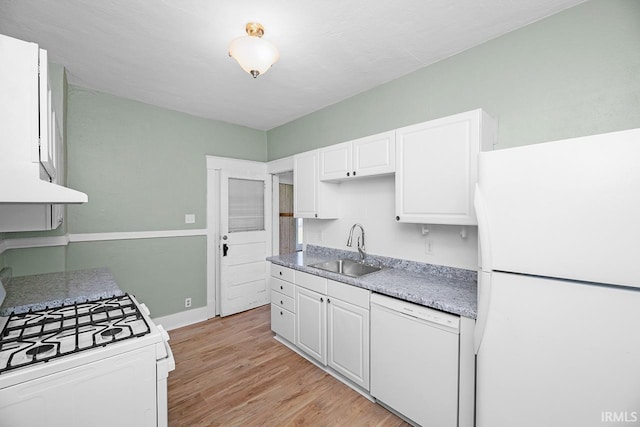 kitchen with white appliances, a sink, light wood finished floors, white cabinets, and baseboards