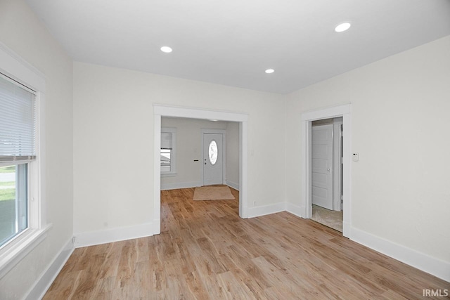 empty room featuring light wood-style floors, baseboards, and recessed lighting