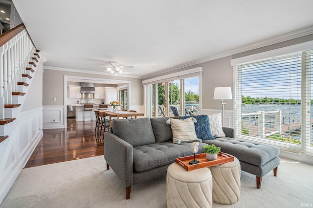411 Auditorium Blvd, Winona Lake, IN 46590 - carpeted living room with crown molding, healthy amount of natural light, stairs, a decorative wall, and a wainscoted wall