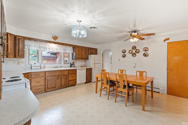 kitchen featuring white appliances, arched walkways, light countertops, a ceiling fan, and a sink