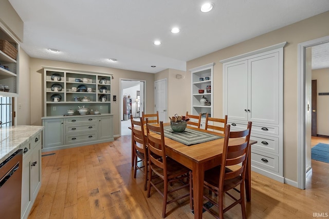 dining space with light wood-style flooring, recessed lighting, and built in features