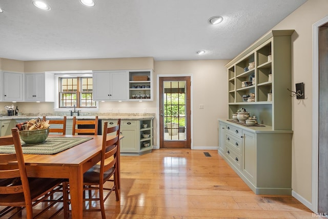 kitchen featuring open shelves, plenty of natural light, light countertops, green cabinetry, and recessed lighting