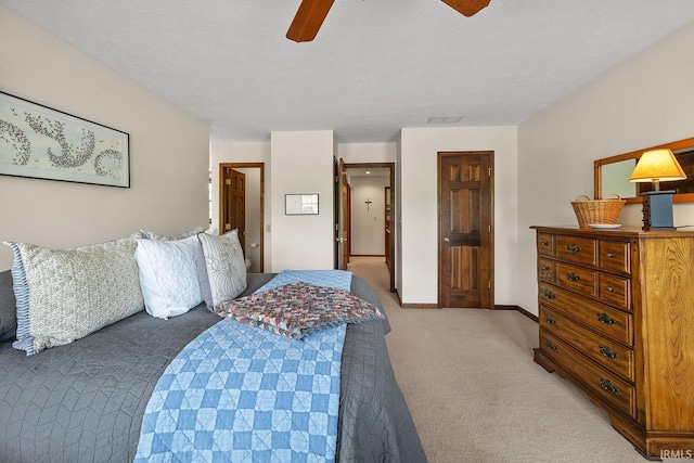 bedroom with light colored carpet, ceiling fan, and a textured ceiling