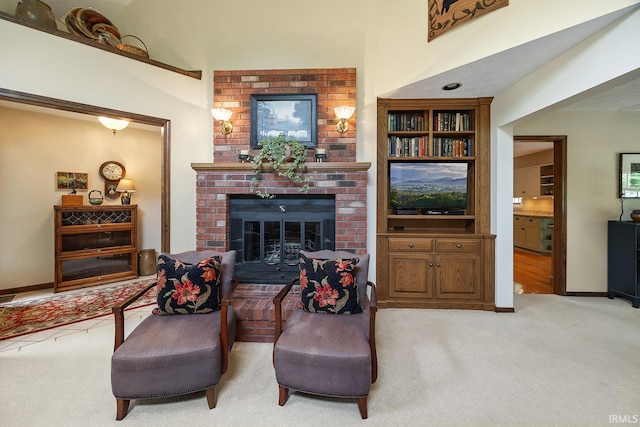 living room featuring light colored carpet, a fireplace, a towering ceiling, and baseboards