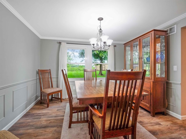 4904 Live Oak Ct, Fort Wayne, IN 46804 - dining room with wood finished floors, ornamental molding, a chandelier, and a decorative wall