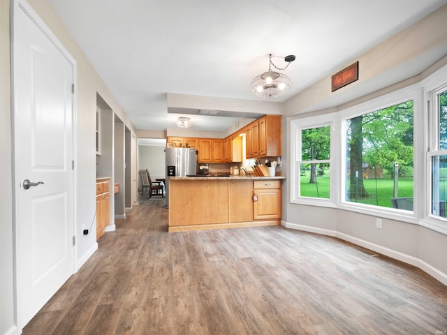 4904 Live Oak Ct, Fort Wayne, IN 46804 - kitchen with stainless steel fridge with ice dispenser, a peninsula, light wood-style flooring, a chandelier, and baseboards