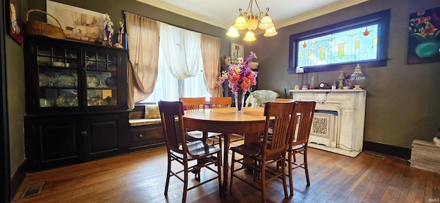 718 N Cherry St, Mount Carmel, IL 62439 - dining room with healthy amount of natural light, ornamental molding, a chandelier, wood finished floors, and a fireplace