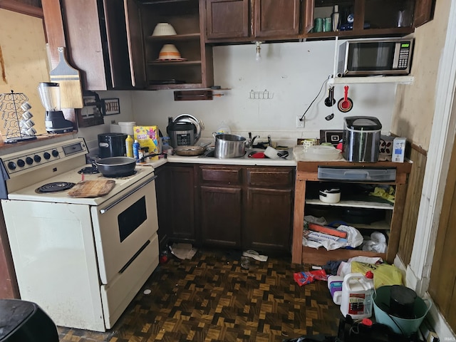 1211 N St, Logansport, IN 46947 - kitchen with white electric stove, stainless steel microwave, open shelves, light countertops, and dark brown cabinets