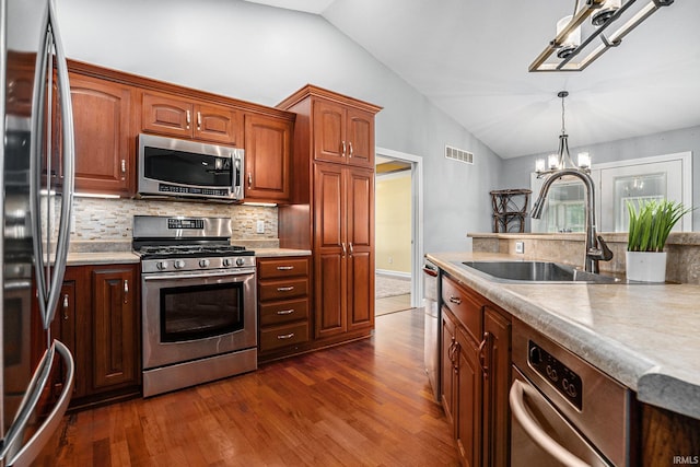 53 Ems C29 Ln, Warsaw, IN 46582 - kitchen featuring stainless steel appliances, lofted ceiling, a sink, a chandelier, and tasteful backsplash