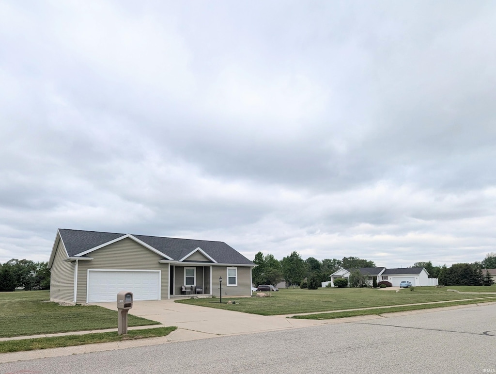 ranch-style house with concrete driveway, a garage, and a front lawn