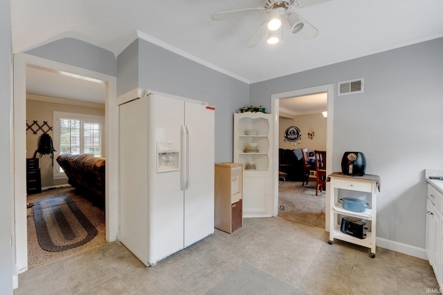 kitchen with white refrigerator with ice dispenser, ornamental molding, ceiling fan, light tile patterned floors, and light countertops