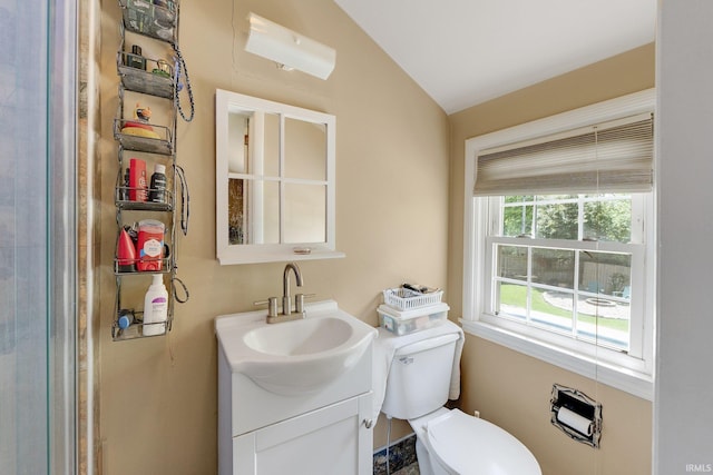 bathroom featuring lofted ceiling, toilet, and vanity