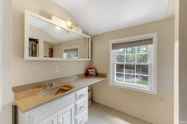bathroom with lofted ceiling, vanity, and tile patterned floors