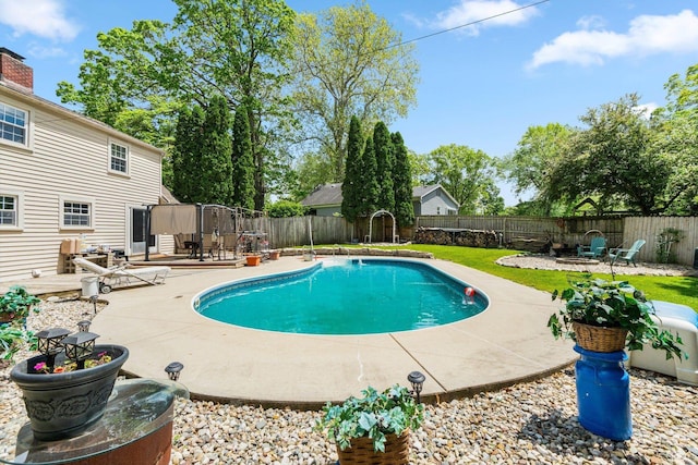 view of swimming pool featuring a fenced backyard, a fire pit, and a patio area