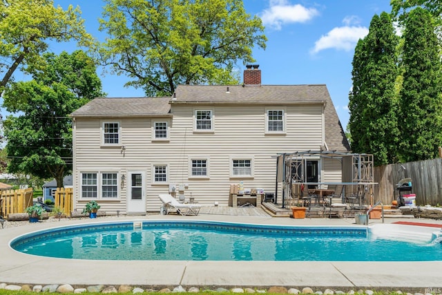 view of swimming pool featuring fence, a wooden deck, and a pergola