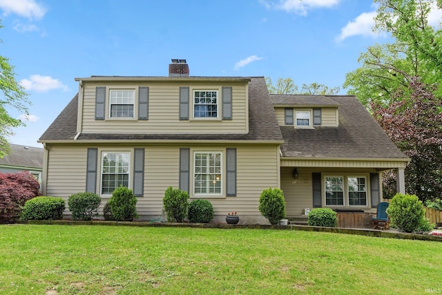 view of front of property with a chimney, a front lawn, a shingled roof, and a porch