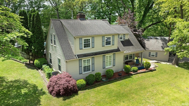 view of front of house featuring a chimney, a front lawn, and a shingled roof