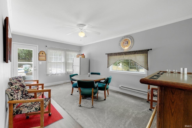 dining area featuring a baseboard radiator, ceiling fan, plenty of natural light, baseboards, and crown molding