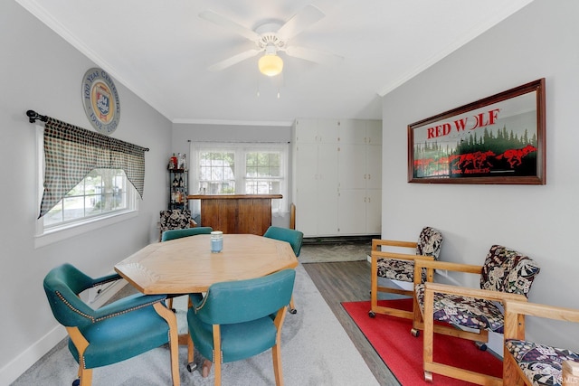 dining room with ornamental molding, ceiling fan, baseboards, and wood finished floors