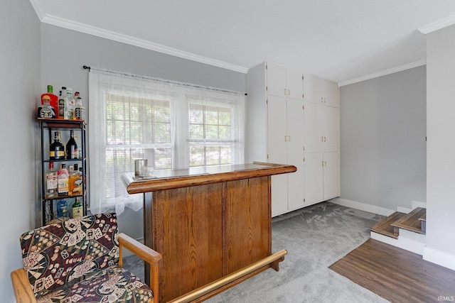 kitchen with ornamental molding, white cabinets, carpet flooring, and baseboards