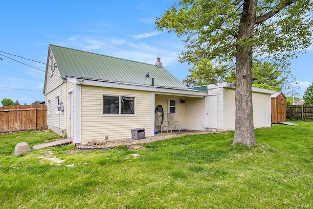1652 N Sheridan St, South Bend, IN 46628 - back of house featuring a storage shed, metal roof, an outbuilding, and a chimney