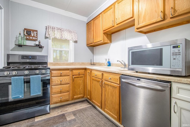 1652 N Sheridan St, South Bend, IN 46628 - kitchen with stainless steel appliances, a sink, crown molding, light wood-type flooring, and light countertops