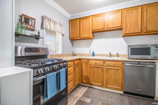 1652 N Sheridan St, South Bend, IN 46628 - kitchen with appliances with stainless steel finishes, light countertops, light wood-type flooring, a sink, and brown cabinets