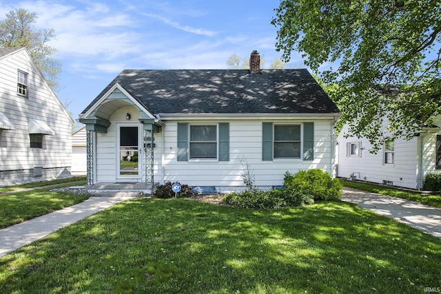 view of front of home with a chimney, a front lawn, and a shingled roof