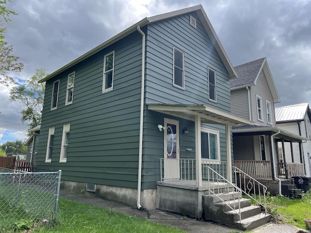 view of front facade featuring a porch and fence