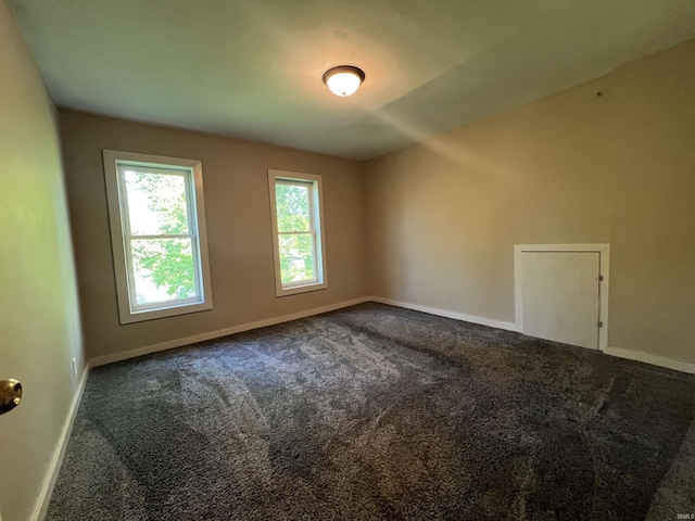 carpeted empty room featuring baseboards