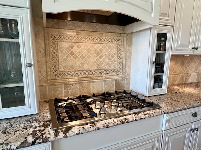 1620 Colonial Dr, Rochester, IN 46975 - kitchen with stainless steel gas cooktop, backsplash, premium range hood, white cabinets, and arched walkways