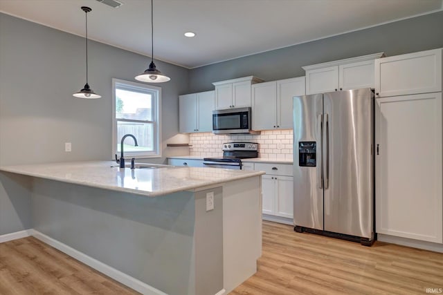 7215 W Mustang Dr, Ellettsville, IN 47429 - kitchen with appliances with stainless steel finishes, a sink, white cabinets, light wood-style flooring, and recessed lighting