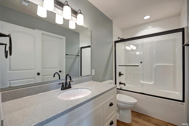 7215 W Mustang Dr, Ellettsville, IN 47429 - bathroom featuring wood finished floors, toilet, shower / bath combination with glass door, and vanity