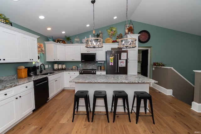30512 Jaxon Dr, Elkhart, IN 46517 - kitchen featuring black appliances, a sink, vaulted ceiling, a kitchen bar, and white cabinets