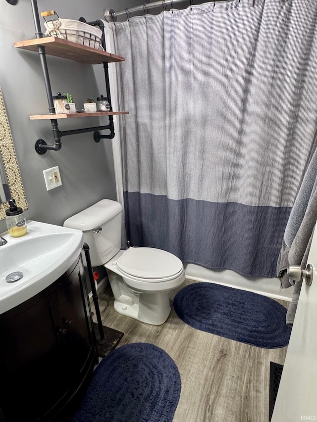 701 N Lincoln Ave, Rockport, IN 47635 - bathroom with toilet, vanity, wood finished floors, and shower / tub combo with curtain
