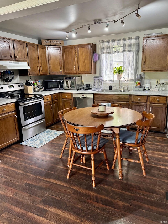 701 N Lincoln Ave, Rockport, IN 47635 - kitchen featuring stainless steel appliances, under cabinet range hood, a sink, light countertops, and dark wood-style flooring