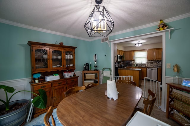6330 Gardner Rd, Chandler, IN 47610 - dining space featuring a chandelier, wainscoting, crown molding, and a textured ceiling