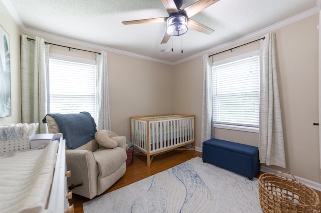 6330 Gardner Rd, Chandler, IN 47610 - bedroom with crown molding, wood finished floors, a nursery area, ceiling fan, and baseboards