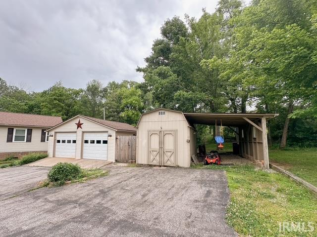 6330 Gardner Rd, Chandler, IN 47610 - garage with a detached garage, a shed, and view of scattered trees