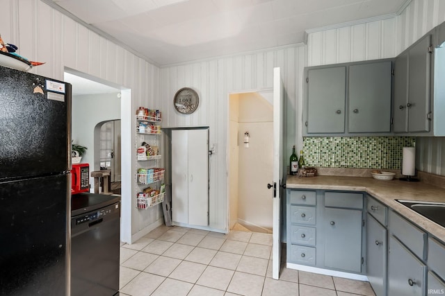 kitchen with black appliances, gray cabinets, light tile patterned flooring, crown molding, and tasteful backsplash