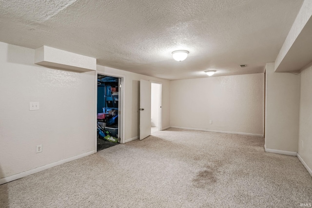 finished basement featuring carpet flooring, a textured ceiling, and baseboards