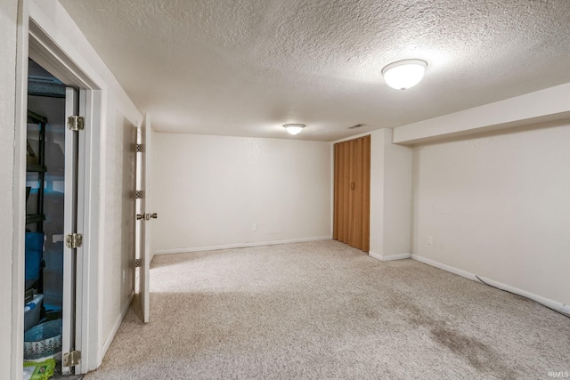 unfurnished room featuring carpet flooring, a textured ceiling, and baseboards