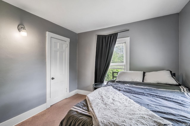 carpeted bedroom featuring baseboards